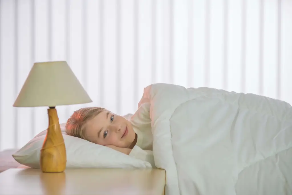 Lapsi sängyssä peiton alla