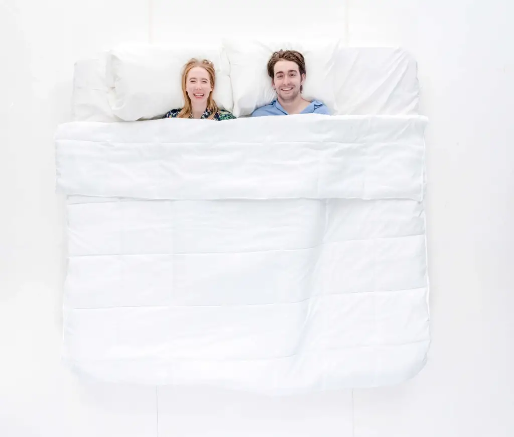 Mies ja nainen makoilemassa sängyssä